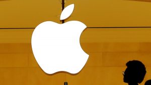 FILE PHOTO: Customers walk past an Apple logo inside of an Apple store at Grand Central Station in New York
