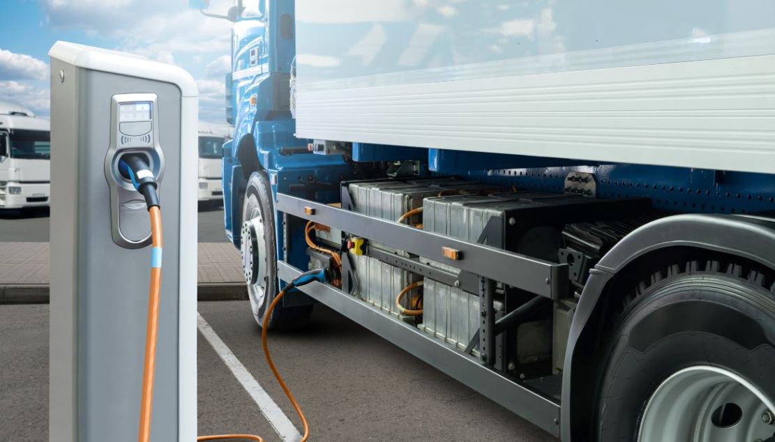 Electric trucks charging at a station. These vehicles help reduce the carbon footprint of the trucking industry.